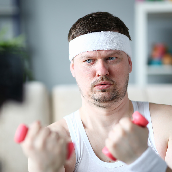 Harry Smith wearing a headband and lifting comically small pink weights.